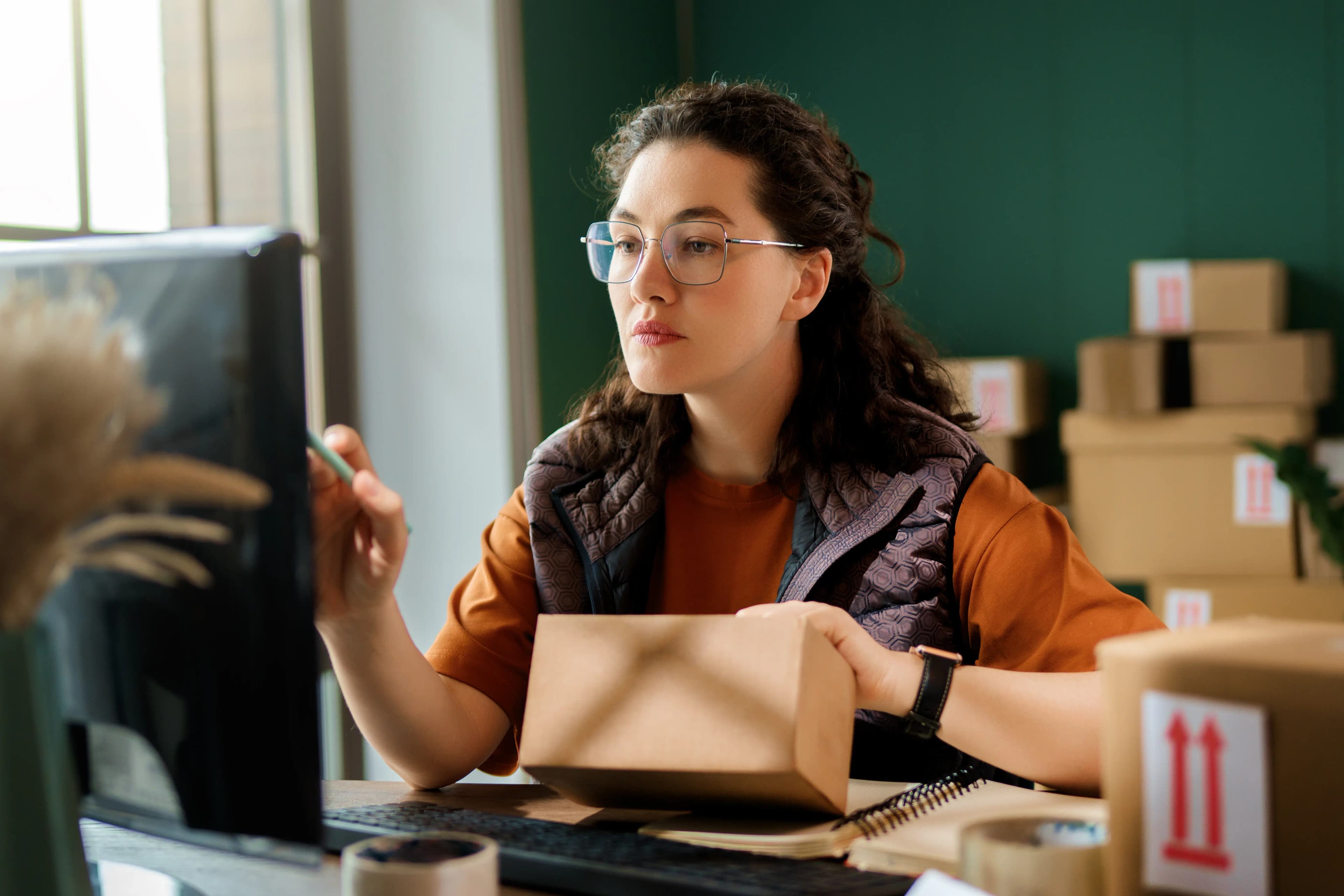 Woman tracking shipment at desk