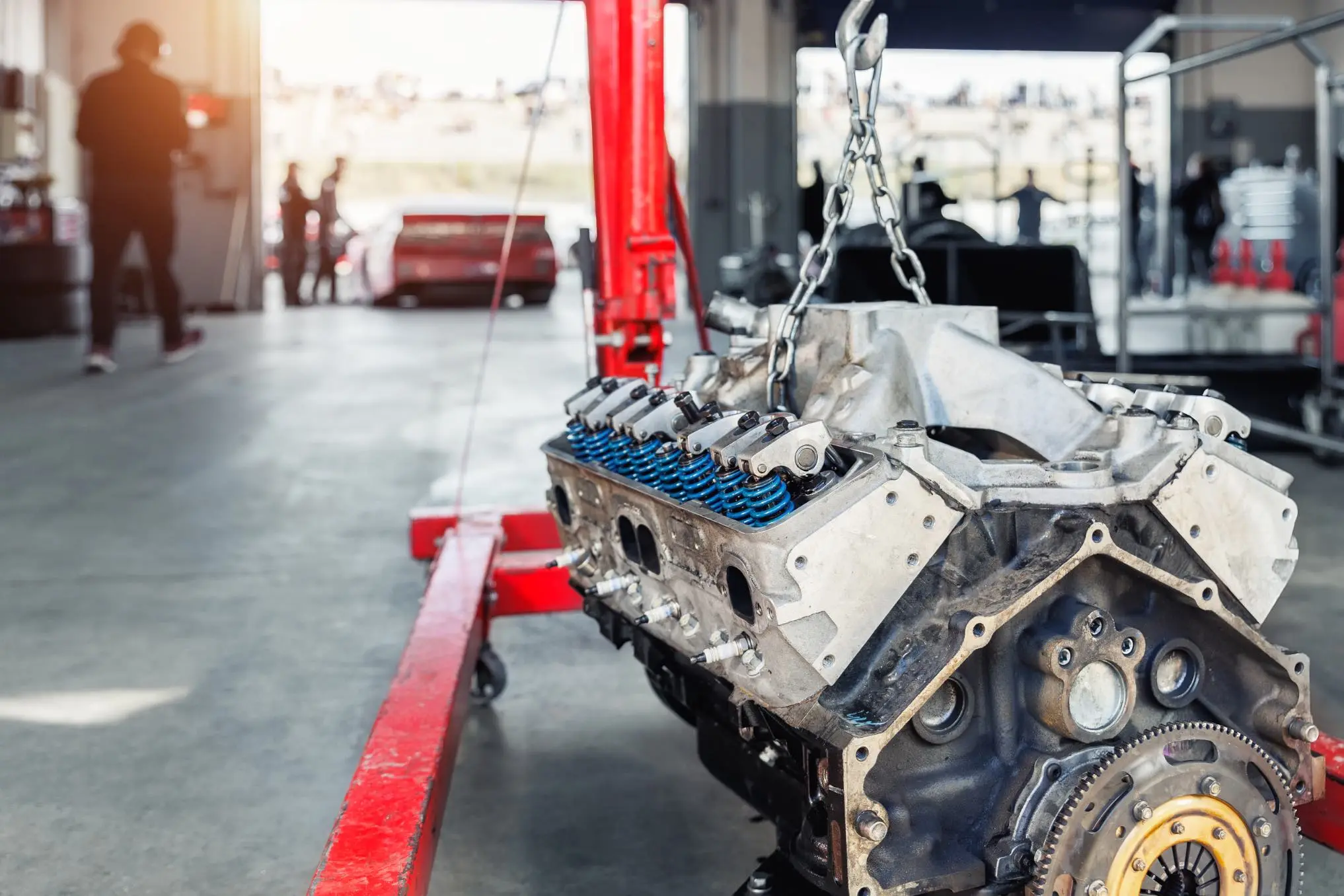 Engine block being lifted by crane in workshop