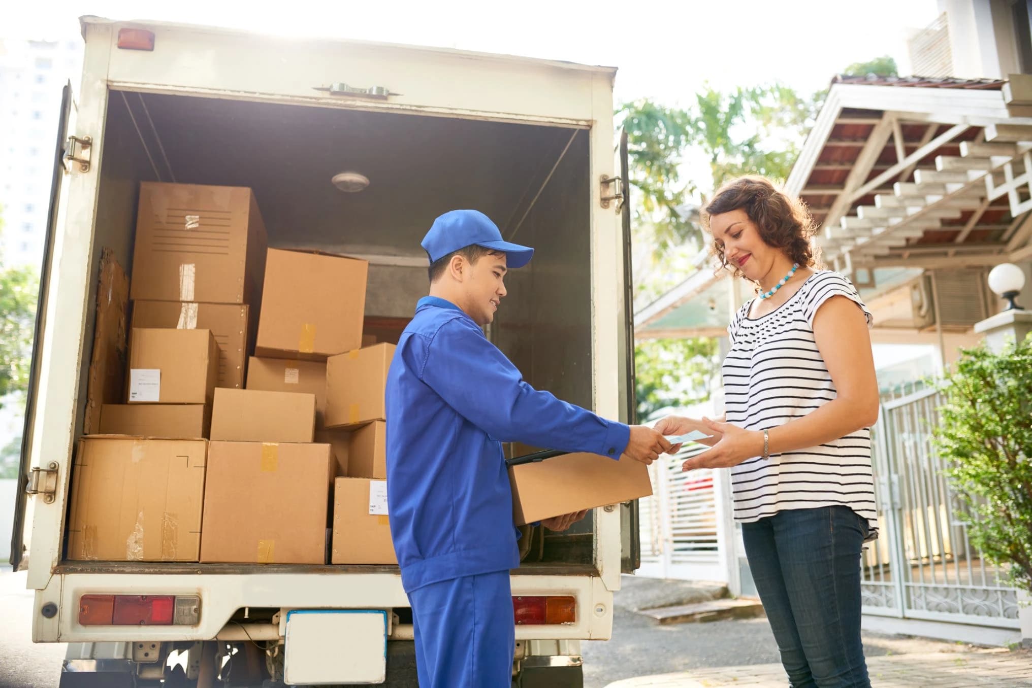 Delivery driver handing package to customer