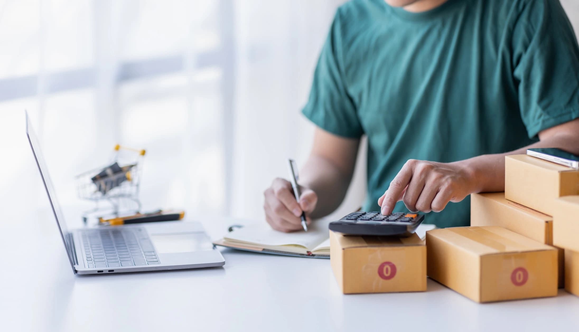 Person calculating shipping costs at desk