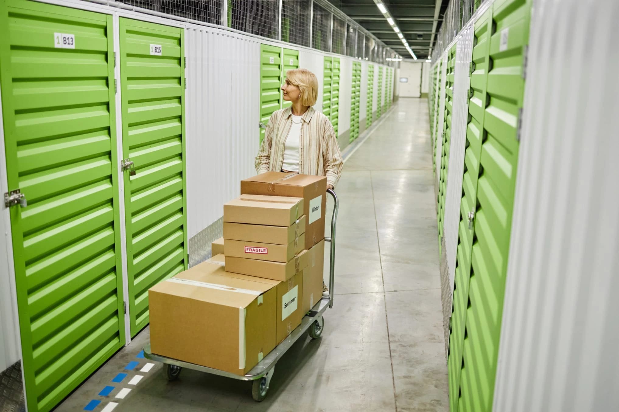 Woman with cart in storage facility aisle